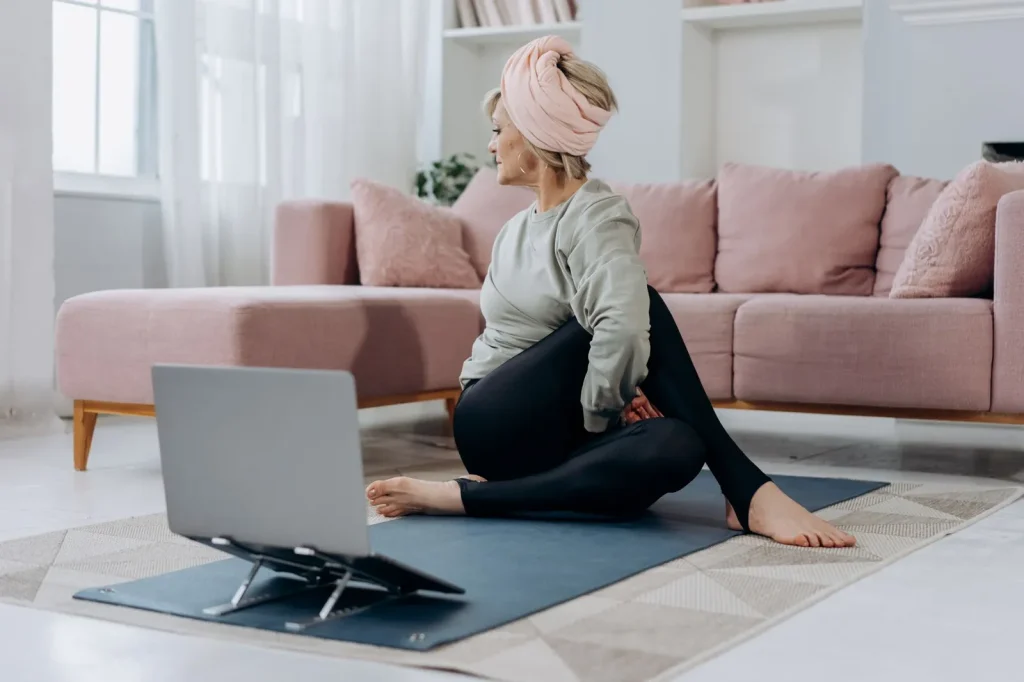 Nő finoman nyújtja a nyakát laptop mellett az irodában